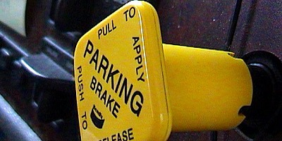 The yellow, four-sided button on the dash controls the parking brakes on the truck or bus.