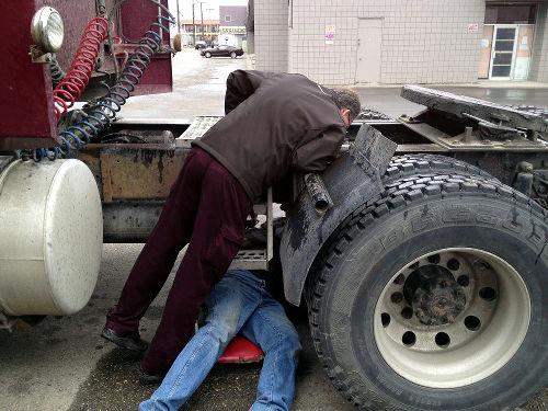 A CDL instructor teaching a student the pre-trip inspection to earn his CDL license.