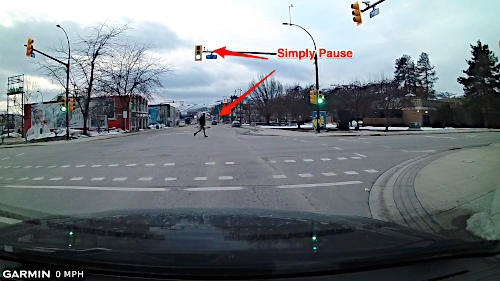 If a pedestrian is in the intersection when the light turns green, simply pause and proceed when they attain the curb.