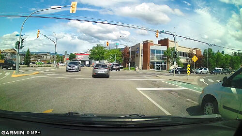If another vehicle is turning left and has positioned their vehicle in the intersection, stay behind the stop line.